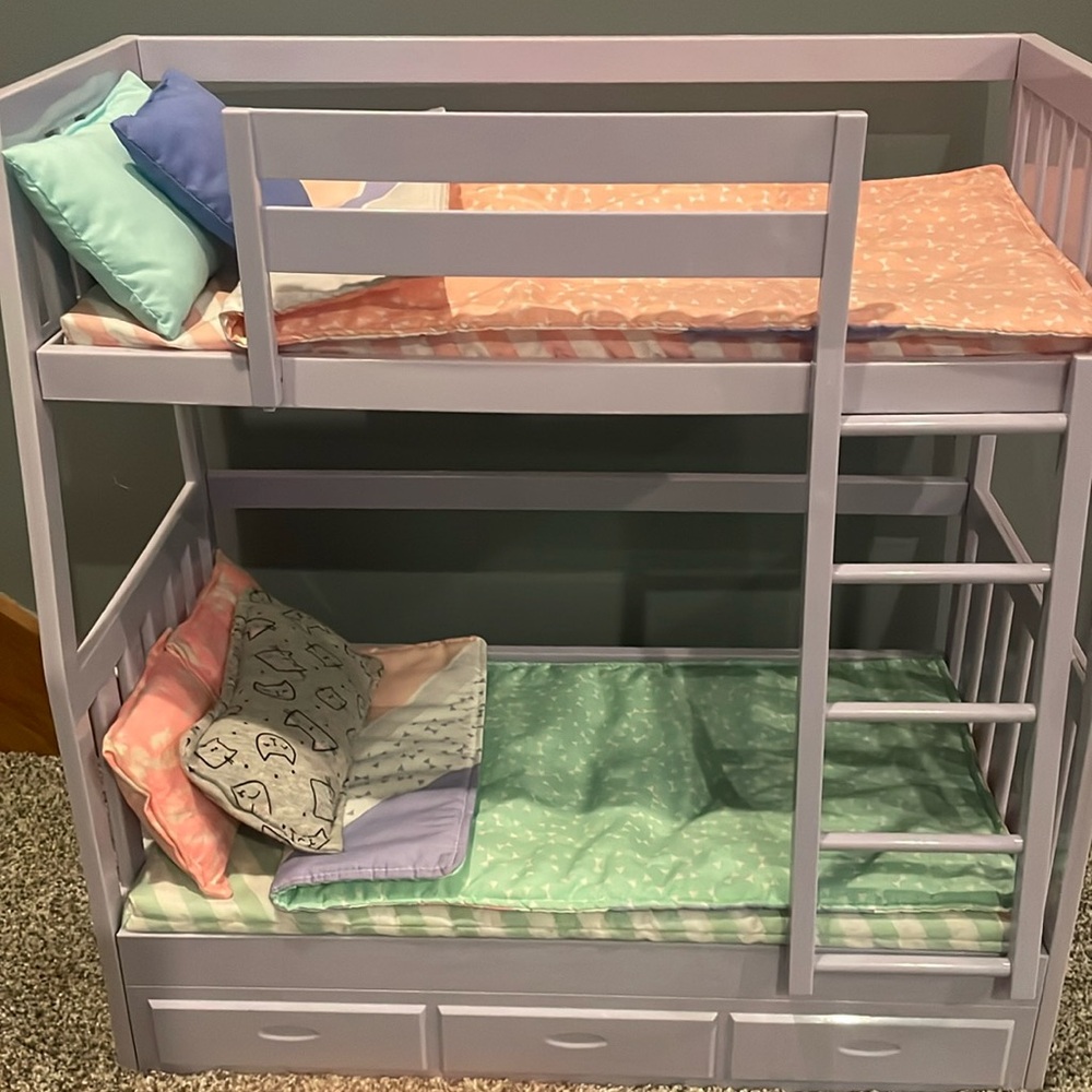 Our generation doll bunkbed. Purple plastic and has bed blankets and pillows.